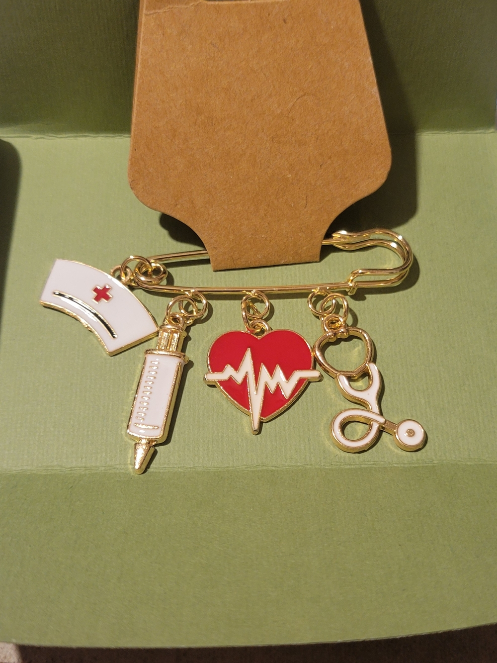 a decorative nursing-themed charm brooch